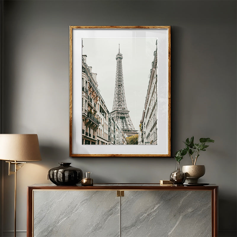 Framed artwork of the Eiffel Tower on a wall above a wooden console table with decorative items.