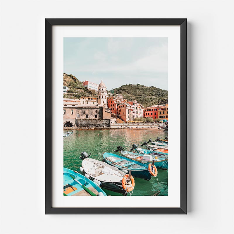 Framed photograph of a coastal scene with boats and buildings.