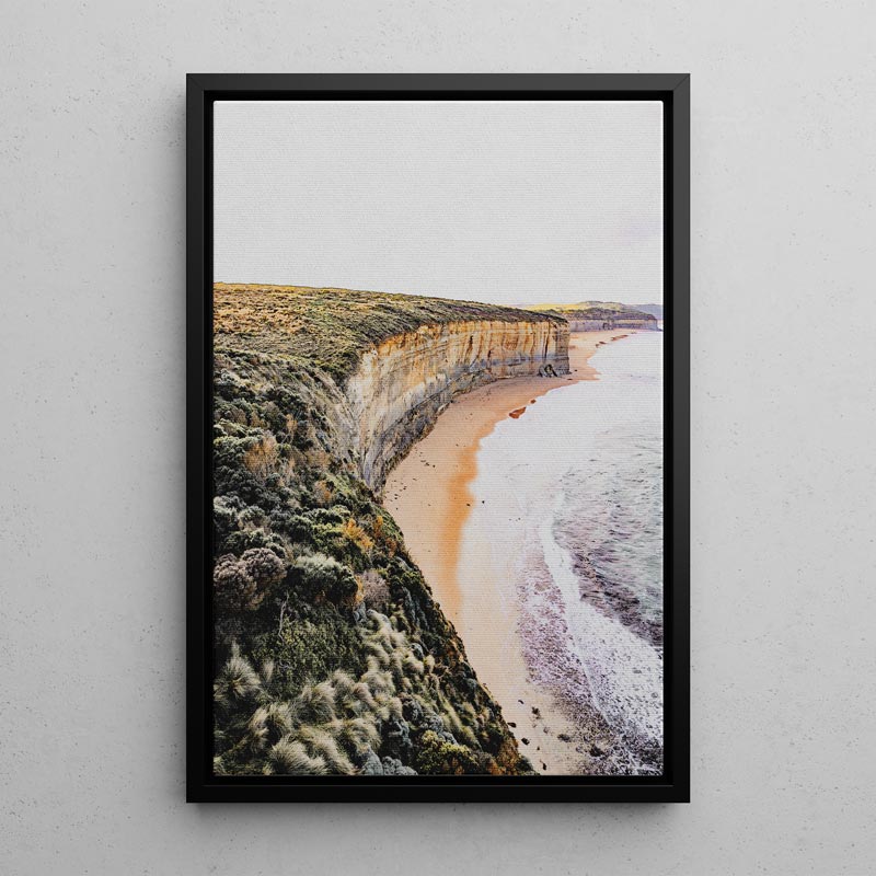 Framed photograph of a coastal landscape with cliffs and beach.