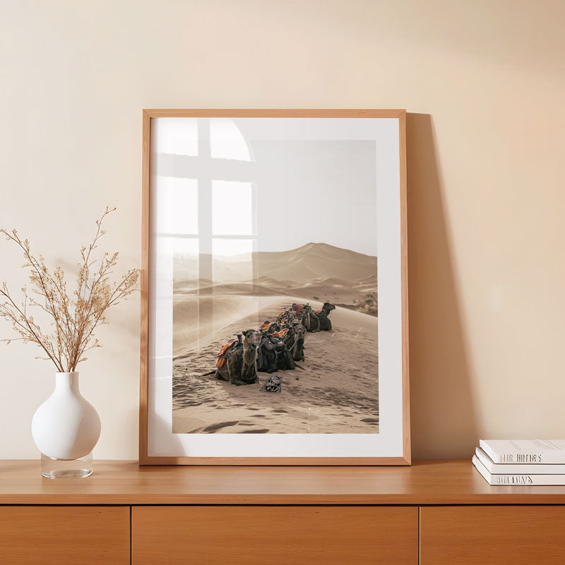 Framed landscape print on a wooden shelf with decor items.