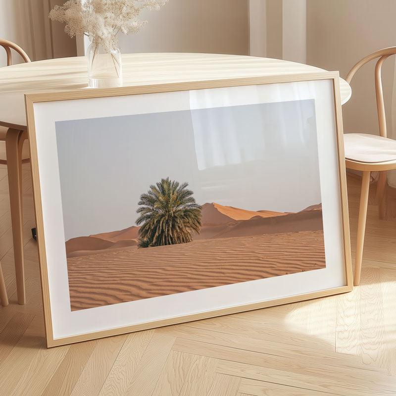 Framed desert landscape print on a wooden floor
