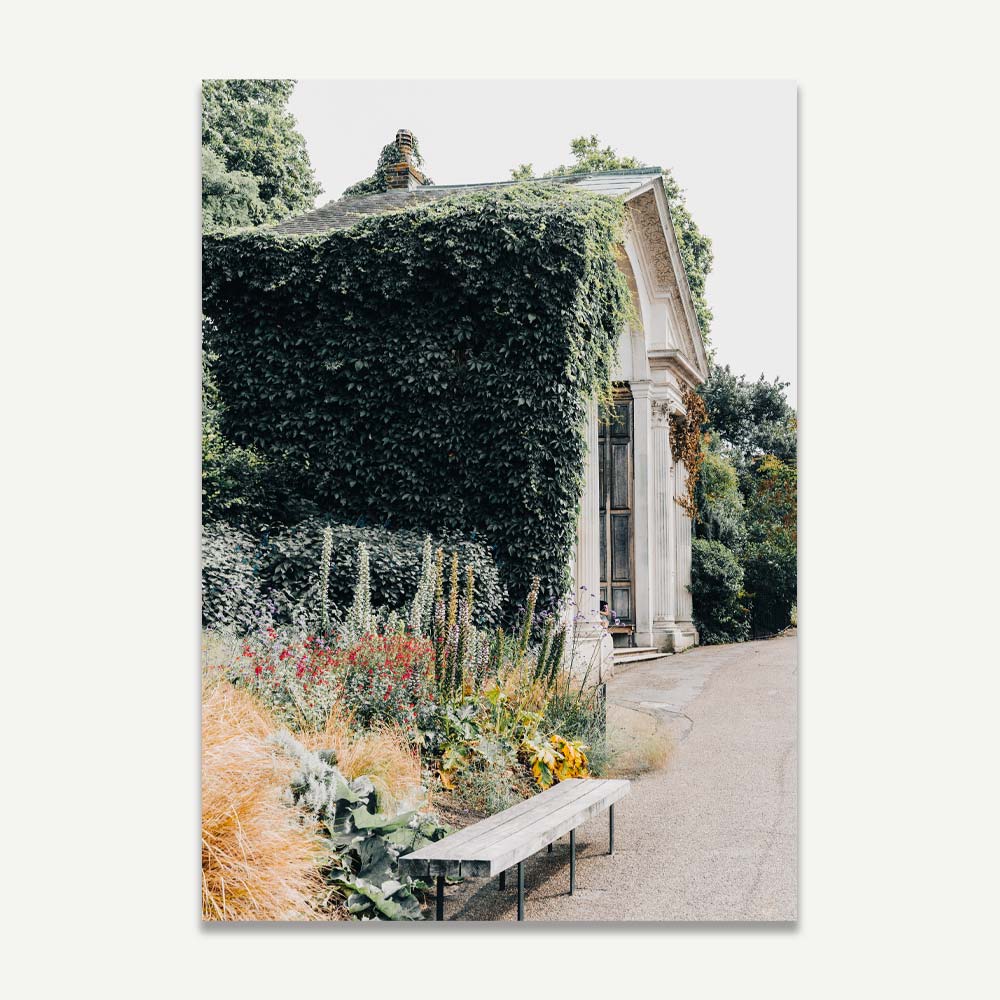 A wall art print featuring a vibrant image of a garden with colorful plants and a building in the background.
