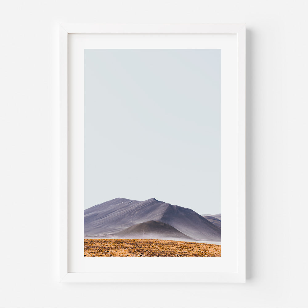 A framed and matted print featuring a landscape photograph with orange and blue hues, titled 'PIEDRAS ROJAS II' by Seus Ku.