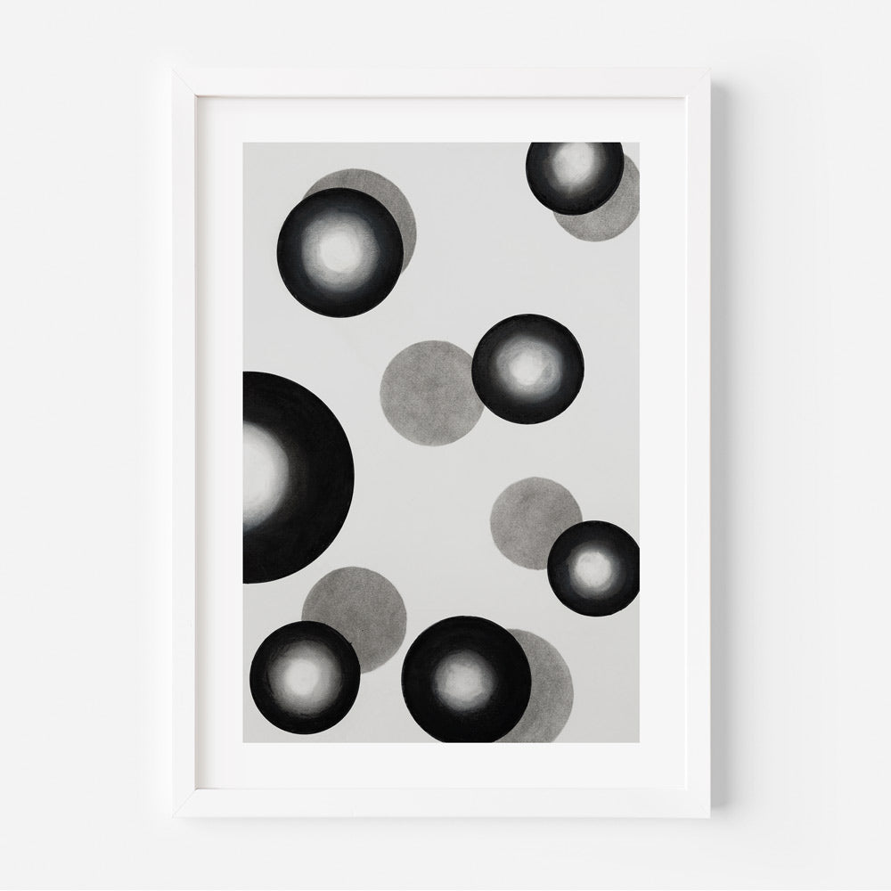 A black and white photograph of abstract circles in various shades displayed in a white frame.