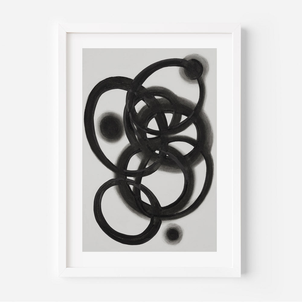 A black and white photograph of an abstract galaxy-like pattern, presented in a frame.