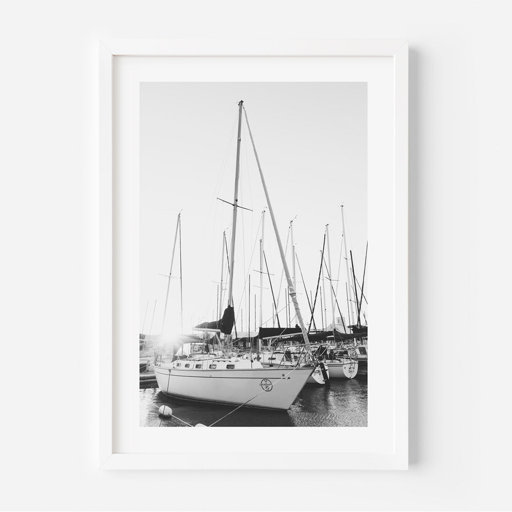 Black and white photograph of a yacht in a marina, framed art piece.