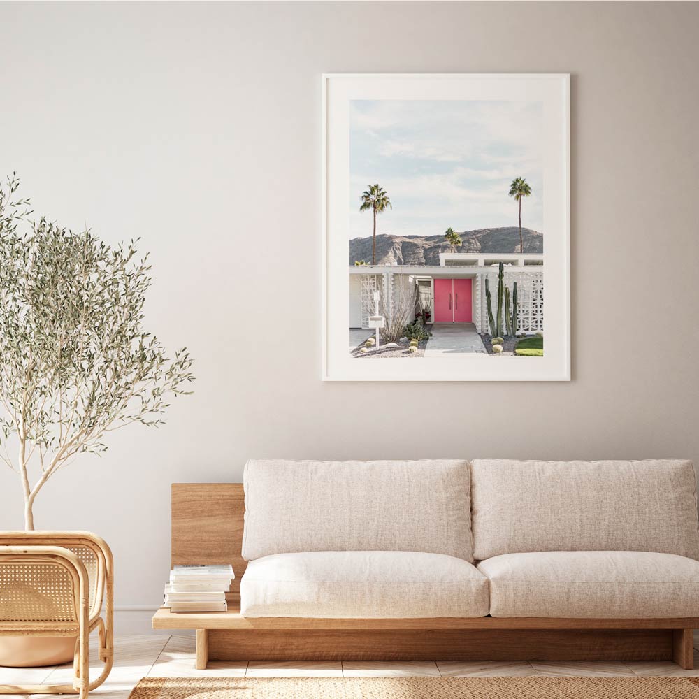 Midcentury modern home with pink door, cacti, and palm trees in Palm Springs, ideal for canvas prints and home decor.
