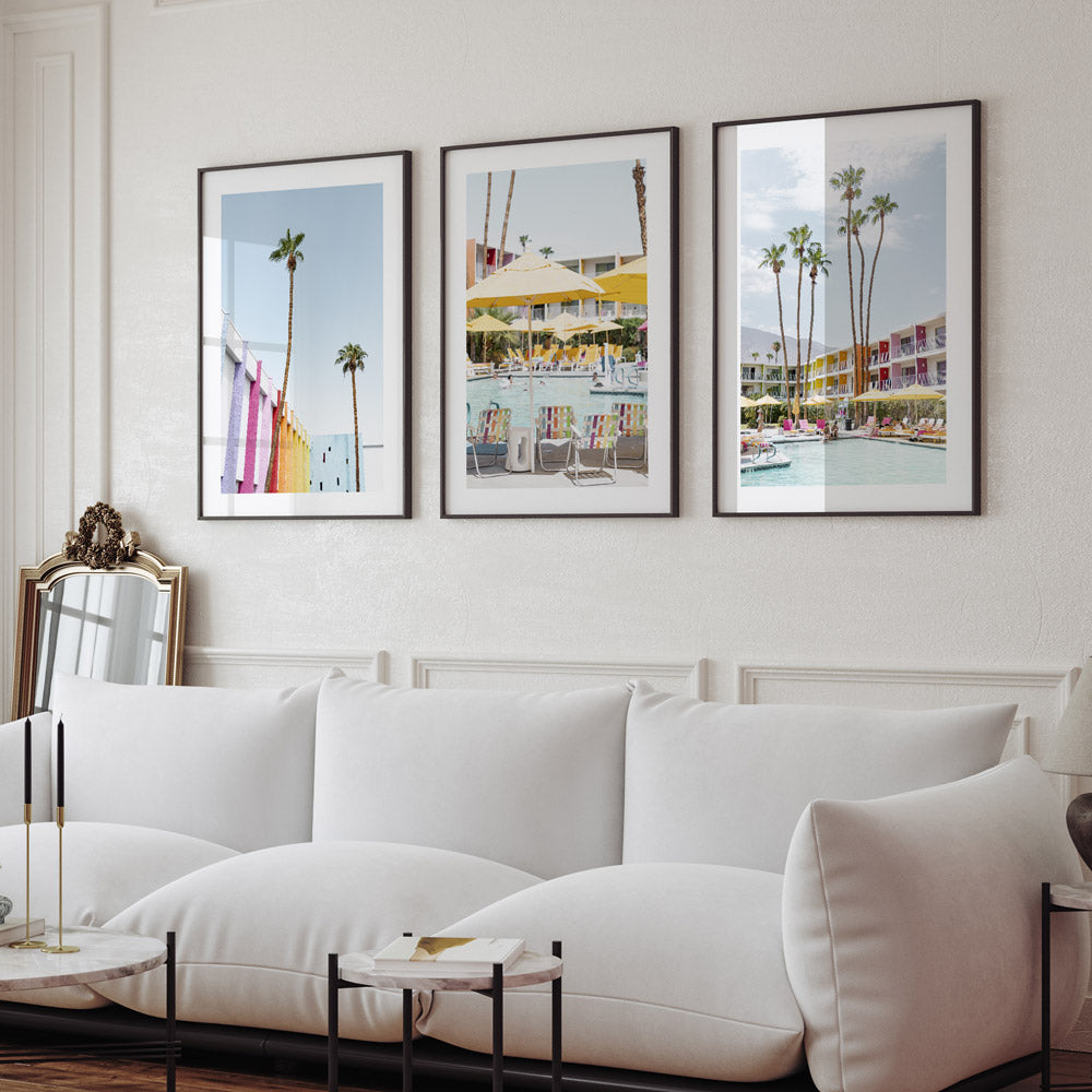 A set of three framed photographs featuring palm trees and colorful buildings, displayed on a wall above a white sofa.