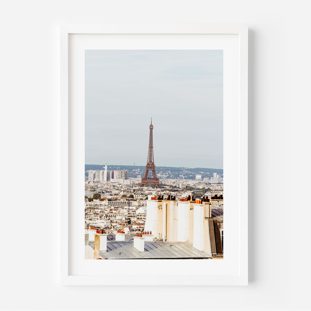 Early morning view from Montmartre, showcasing soft light over Parisian rooftops and the Eiffel Tower.
