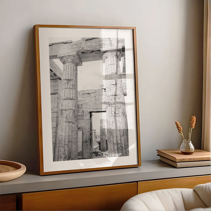 Framed black and white photo of ancient architecture on a shelf with decorative items.