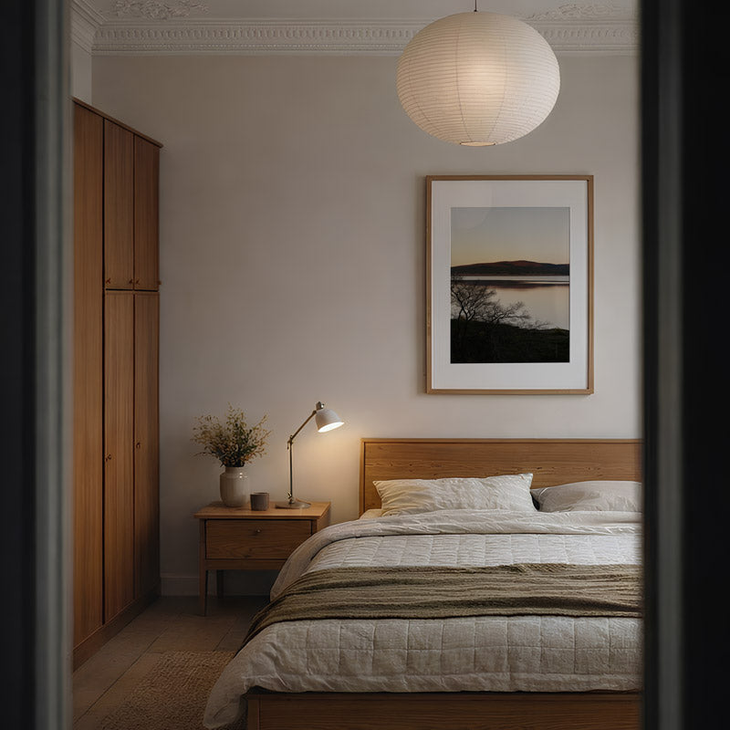 Cozy bedroom with wooden bed, nightstand, and wall art.