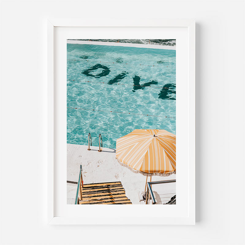 Framed photograph of a pool with 'Dive' text and an umbrella on a white background