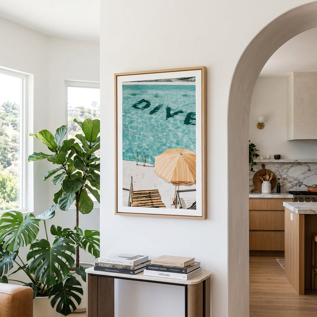 Living room with a framed picture of a beach scene, books, and a plant.