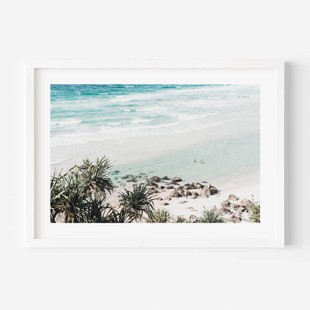 Framed coastal wall art featuring a peaceful beach day with desaturated tones and ocean hues
