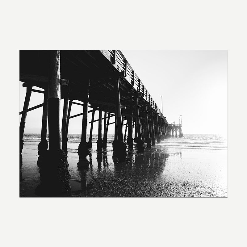 Black and white photo of a long pier extending into the water.