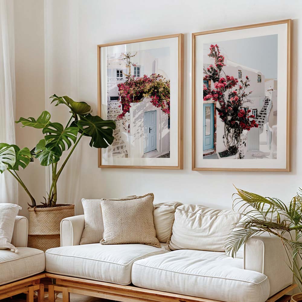 Two house with blue doors and floral facade framed art hung in a living room