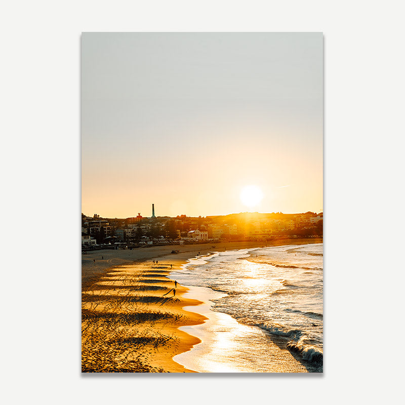 Beach scene with sunrise casting a warm glow over the water and shoreline.
