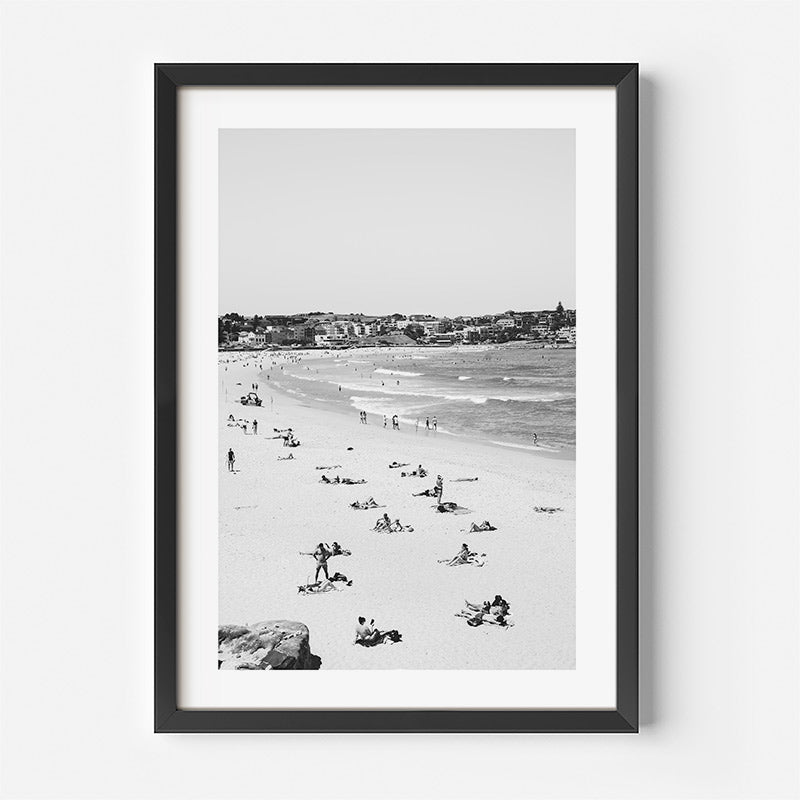 Framed black and white beach scene print on a white wall