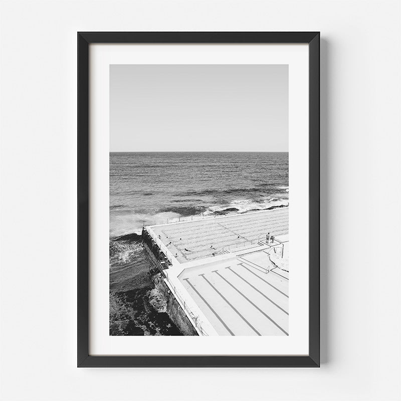 Framed black and white photograph of a coastal scene with a wooden walkway.