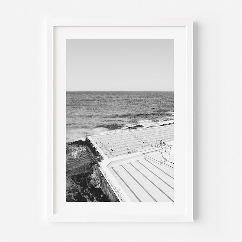 Framed black and white photograph of a coastal scene with a wooden walkway.
