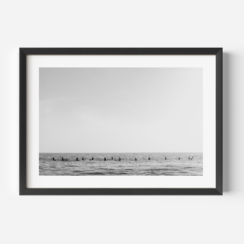 Framed black and white photograph of a row of ducks on water against a gray sky.