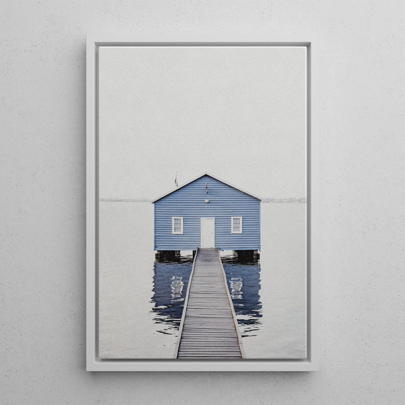 Framed photograph of a blue building with a dock on a gray wall