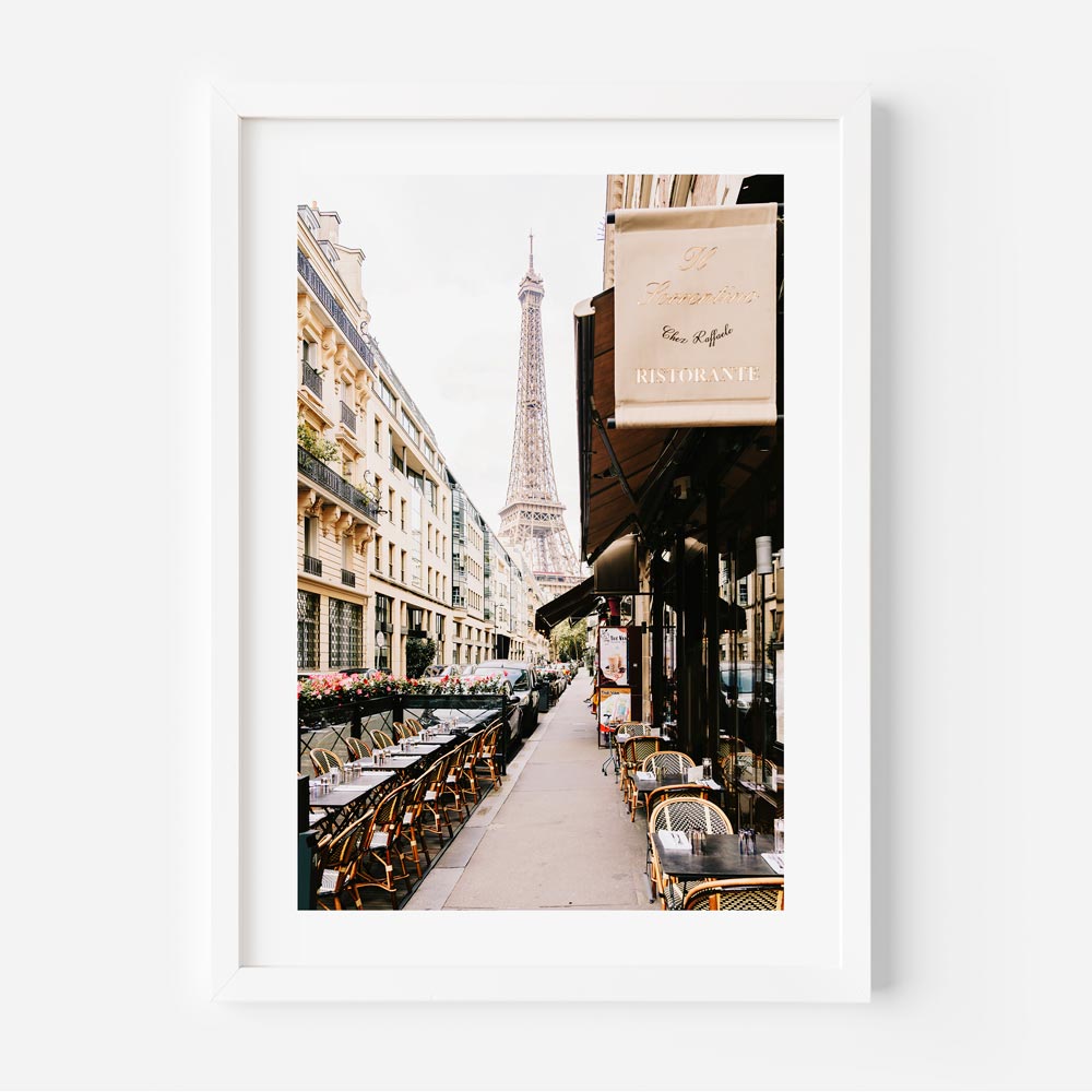 Eiffel Tower framed by Parisian buildings and cafés along Rue de Monttessuy, capturing the essence of Parisian life.
