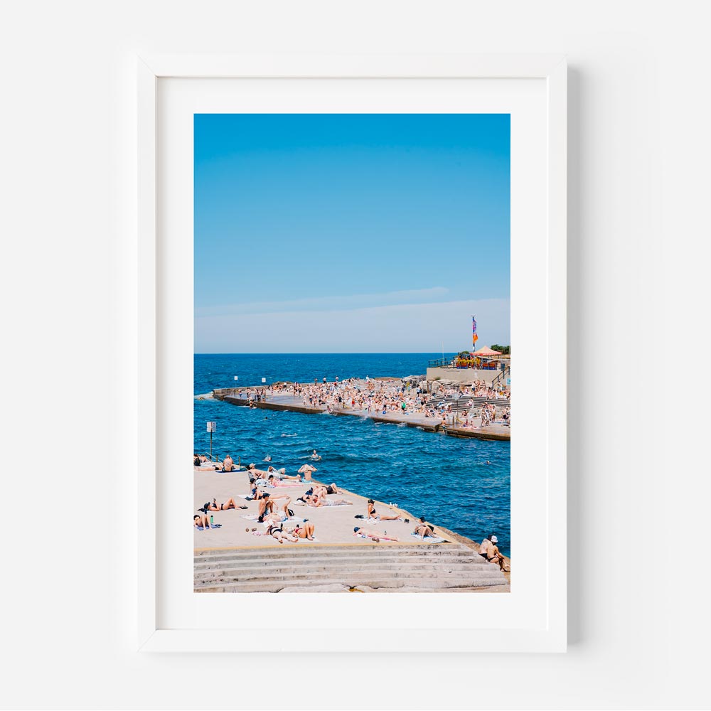 Vibrant summer scene at Clovelly, Sydney: Beachgoers embracing the sun and sea - Elevate your wall decor with captivating wall art from Oblongshop.