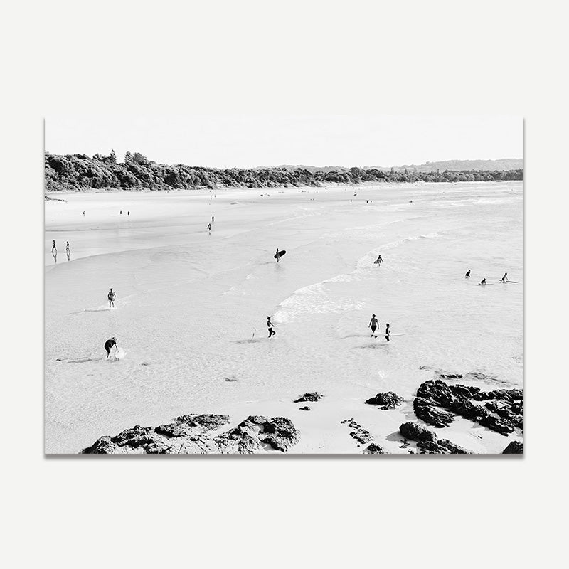 Black and white photo of a beach scene with people and a kangaroo.
