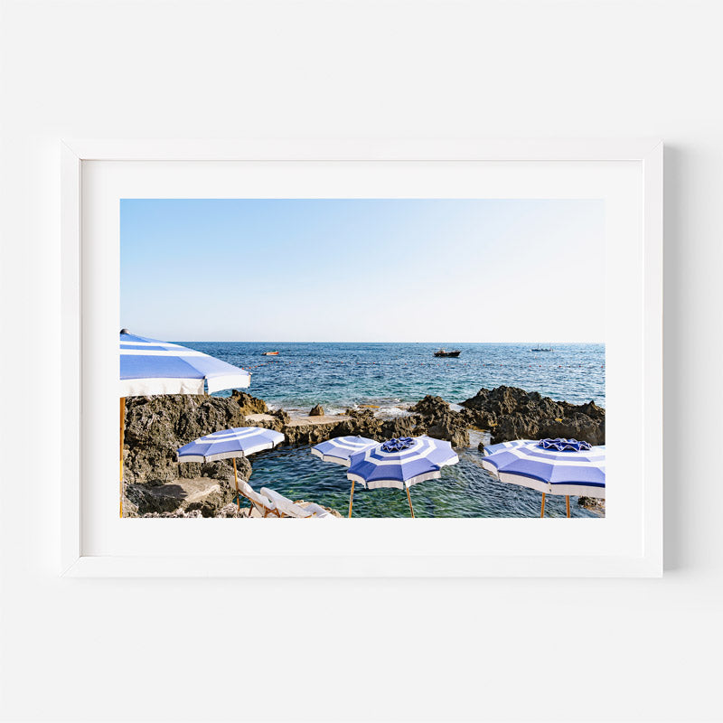 Framed photograph of beach umbrellas by the sea with a white border