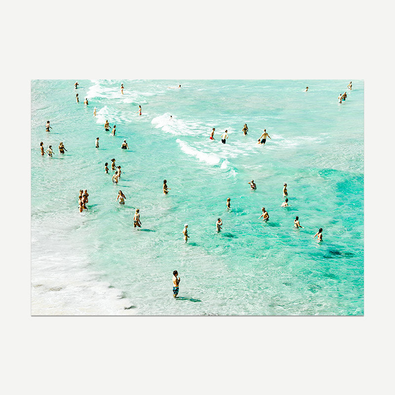 People enjoying the clear turquoise water at a beach.