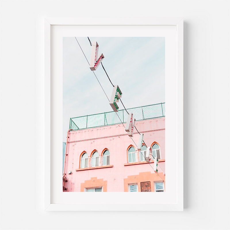 Framed photograph of a pink building with a clear blue sky.