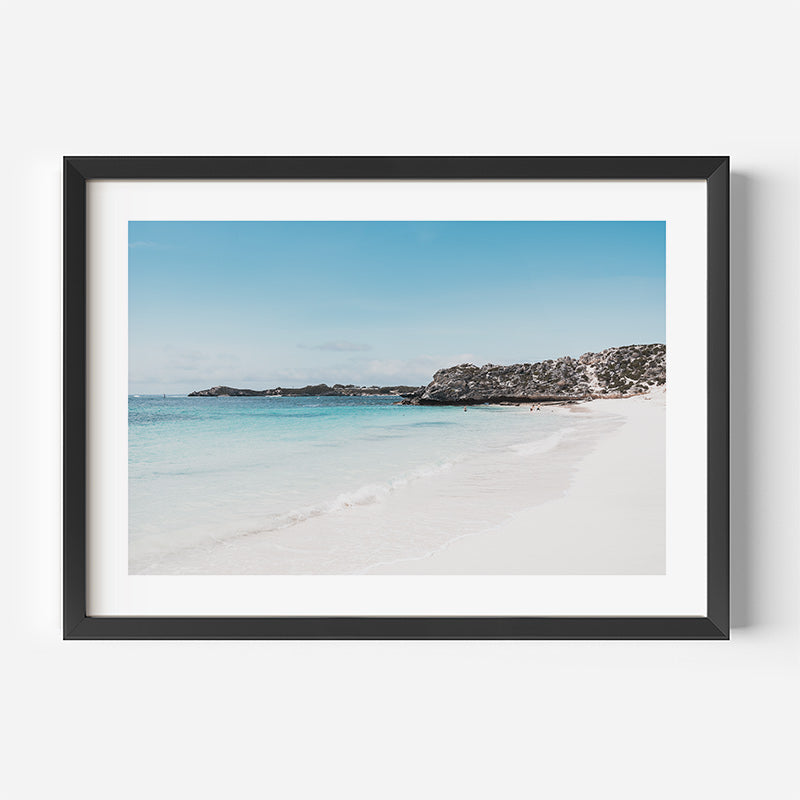 Framed photograph of a beach with clear blue water and sky.