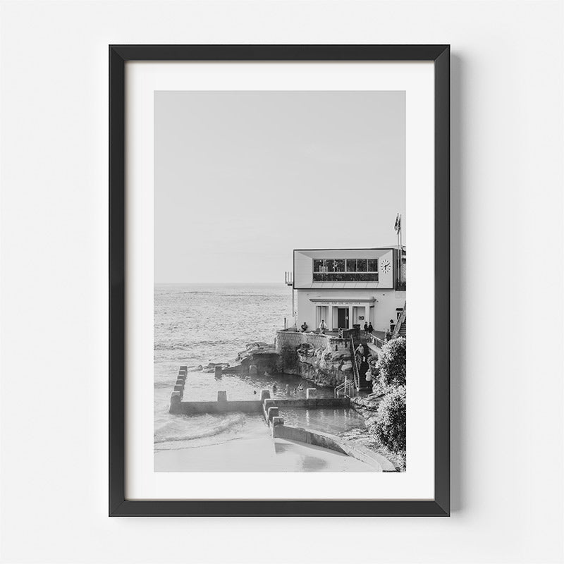 Framed black and white photograph of a coastal building with ocean view.