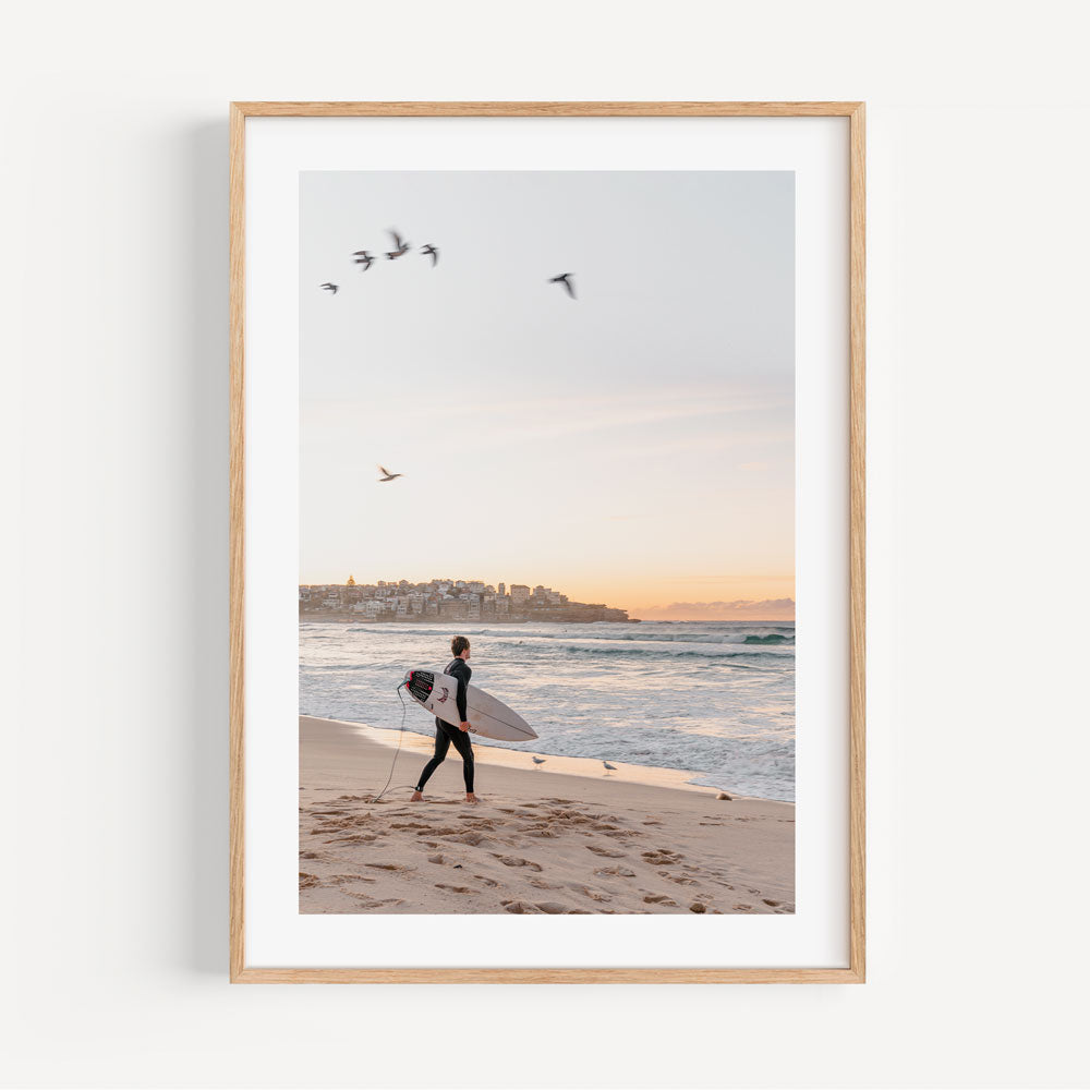 Surfing at Dawn: Scenic view of a lone surfer at Bondi Beach, perfect for coastal-themed wall art and home decor.