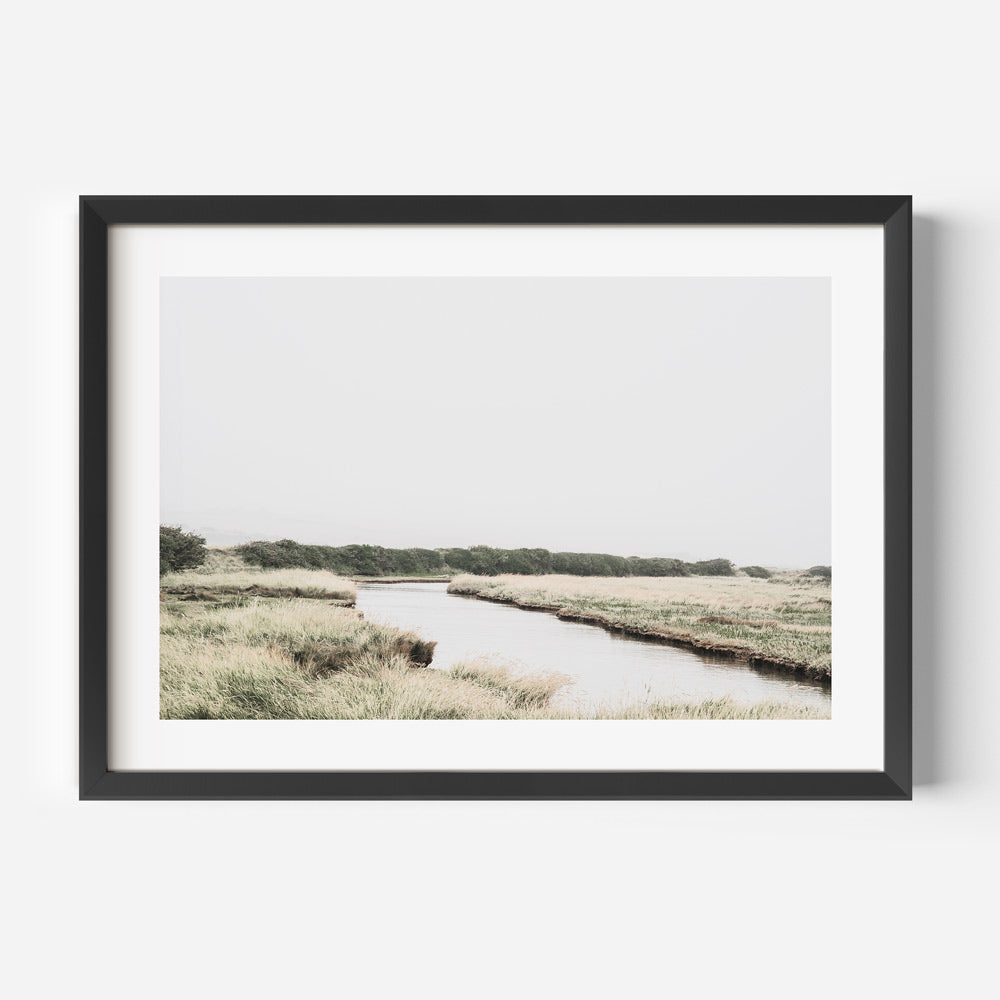 Enhance your home or office with this stunning wall art of a river amidst a beautiful field in East Sussex, UK.