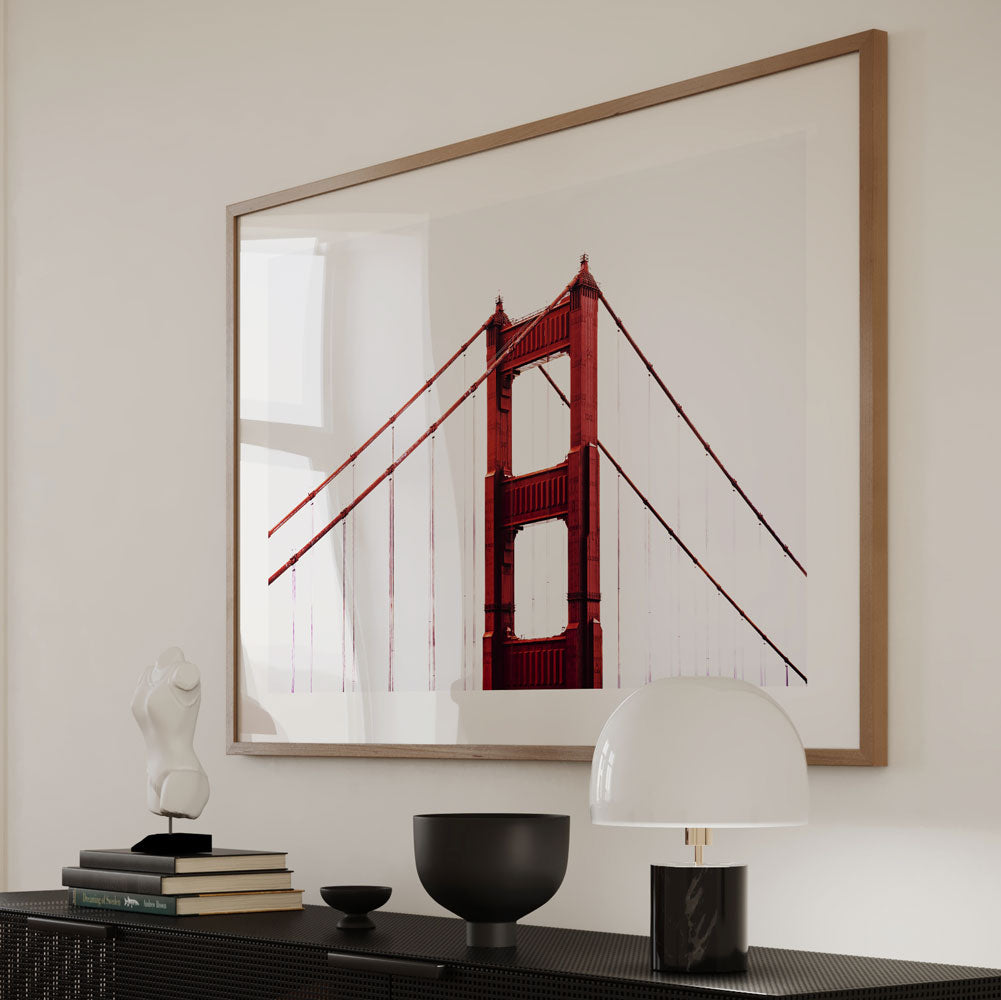 Framed art print of the Golden Gate Bridge, showcasing its striking architecture against a cloudy backdrop.