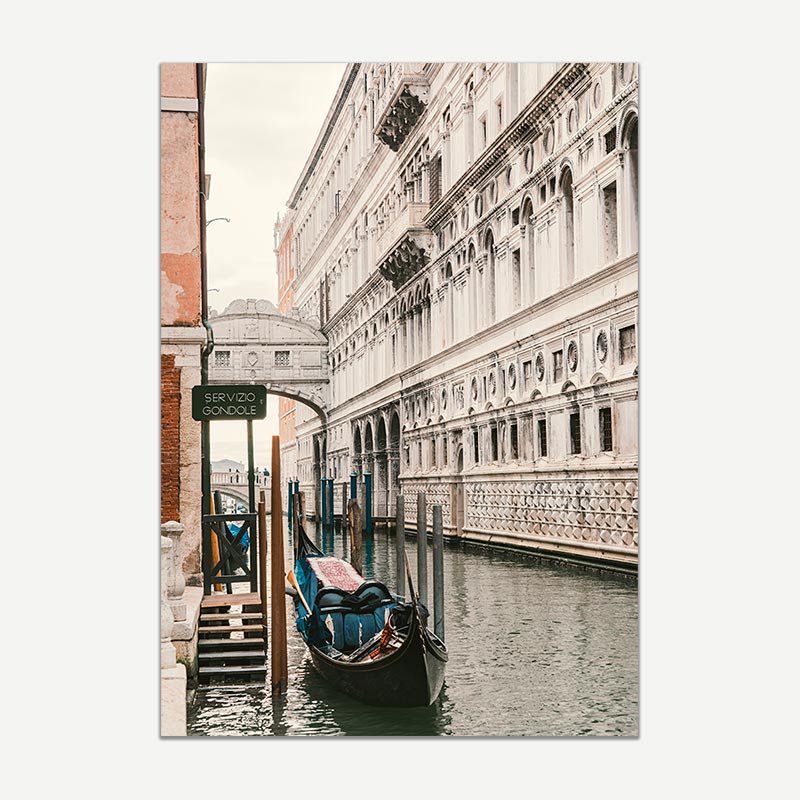 Gondolas docked along a canal in Venice with historic buildings.