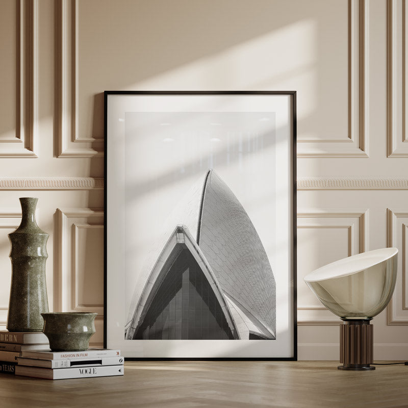 Framed black and white abstract art piece on a wall with decorative elements.