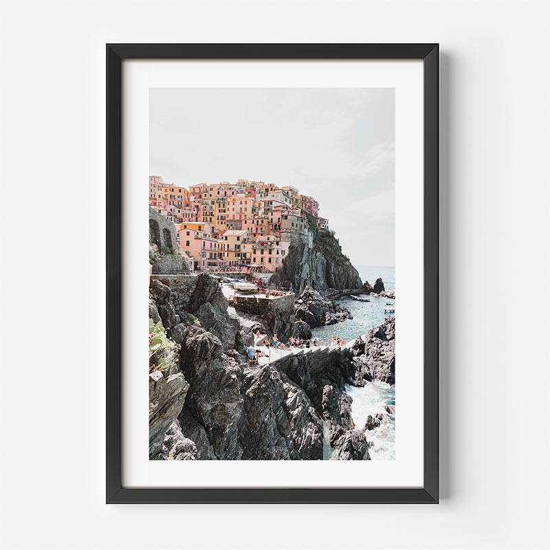 Framed photograph of a coastal town with colorful buildings on a cliff.