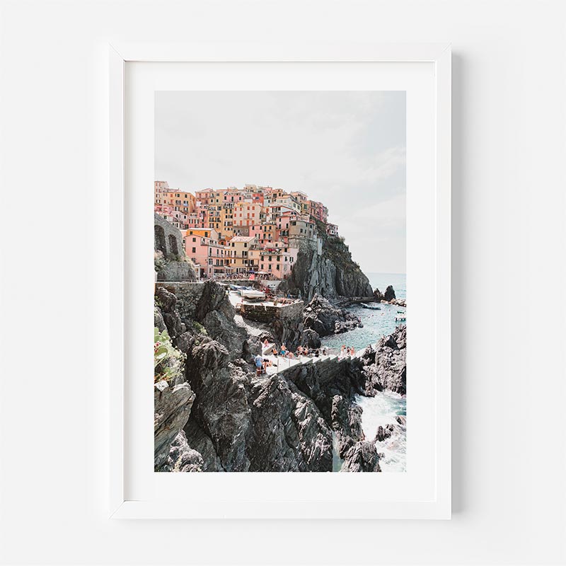 Framed photograph of a coastal village with colorful buildings on a cliff.