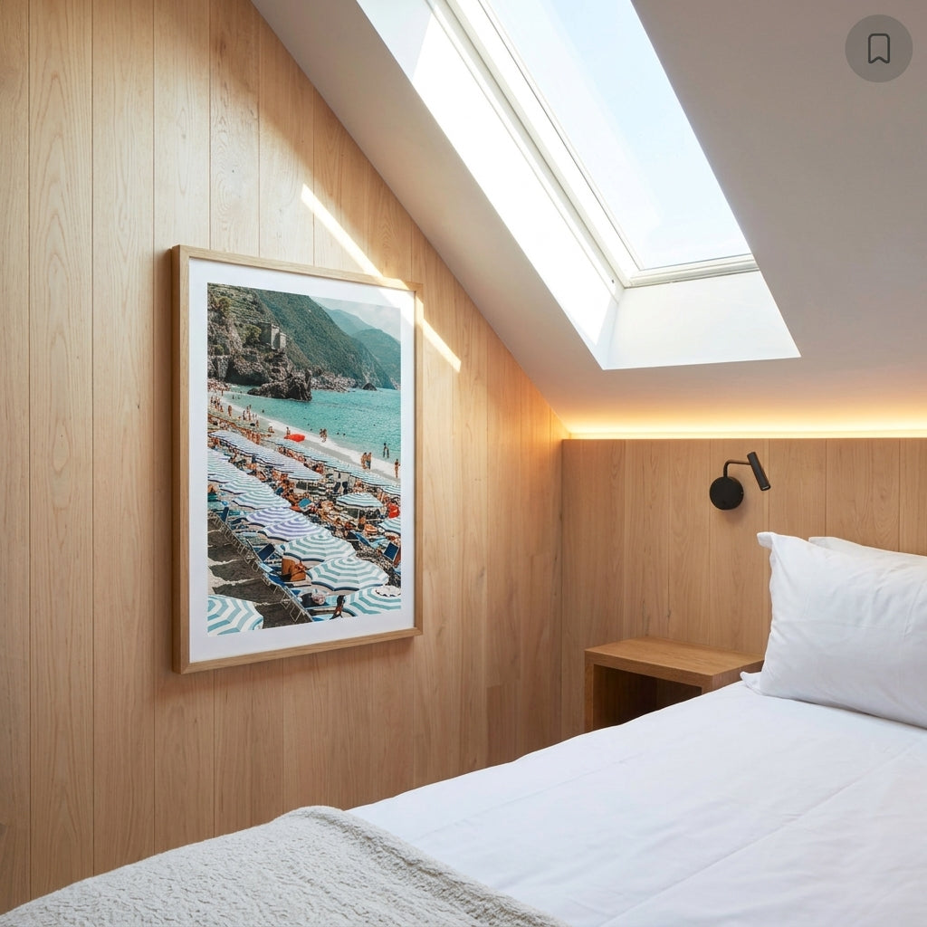 Modern bedroom with wooden walls, a bed, and a framed picture of a beach scene.