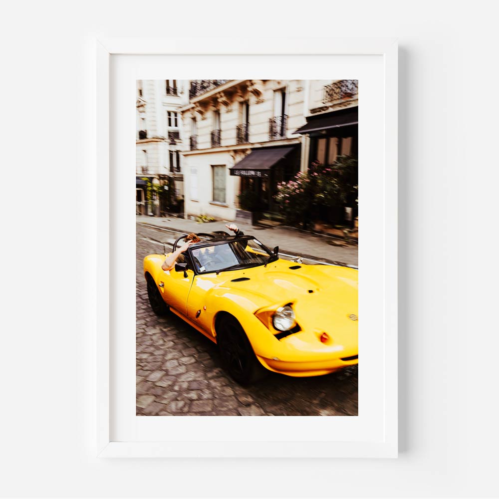 Yellow sport car passing through a Parisian street captured in stunning wall art, perfect for home decor.
