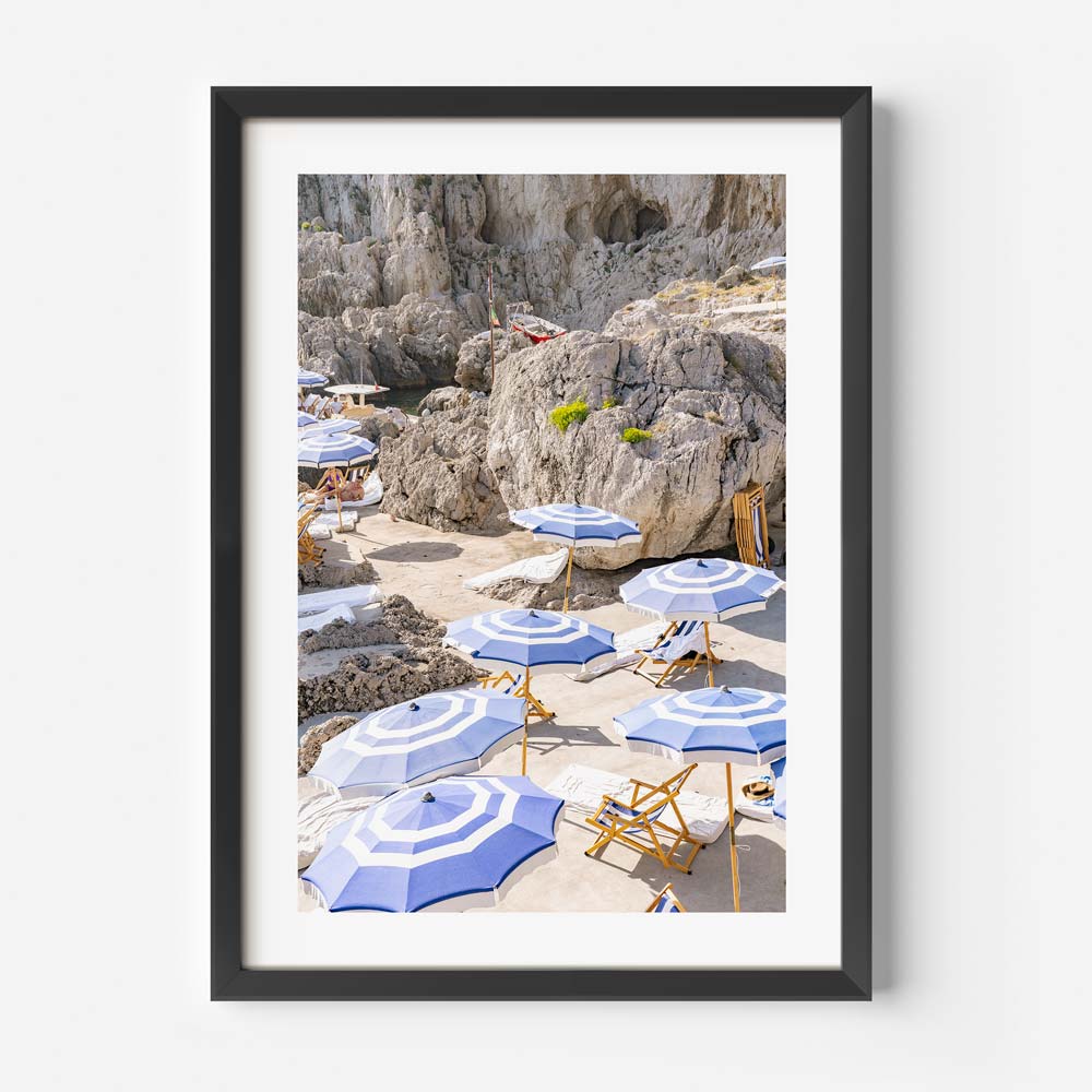 Sunny Days in Capri: Sunbathing chairs and umbrellas at La Fontelina, Capri, Italy, against scenic mountains, perfect for contemporary home decor.
