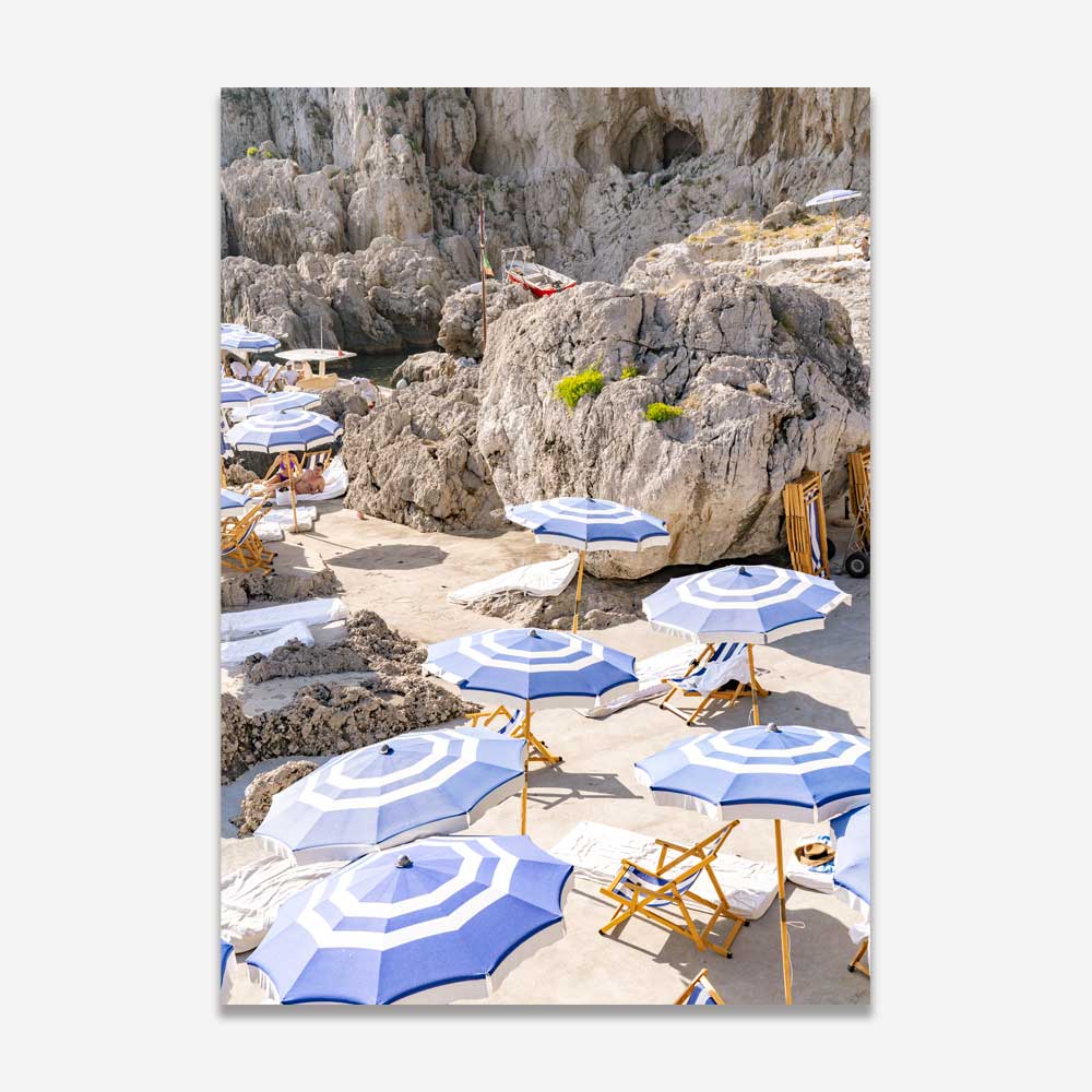 Italian Riviera Bliss: Sunbathing chairs and umbrellas at La Fontelina, Capri, Italy, against picturesque mountains, infusing coastal tranquility into your space.