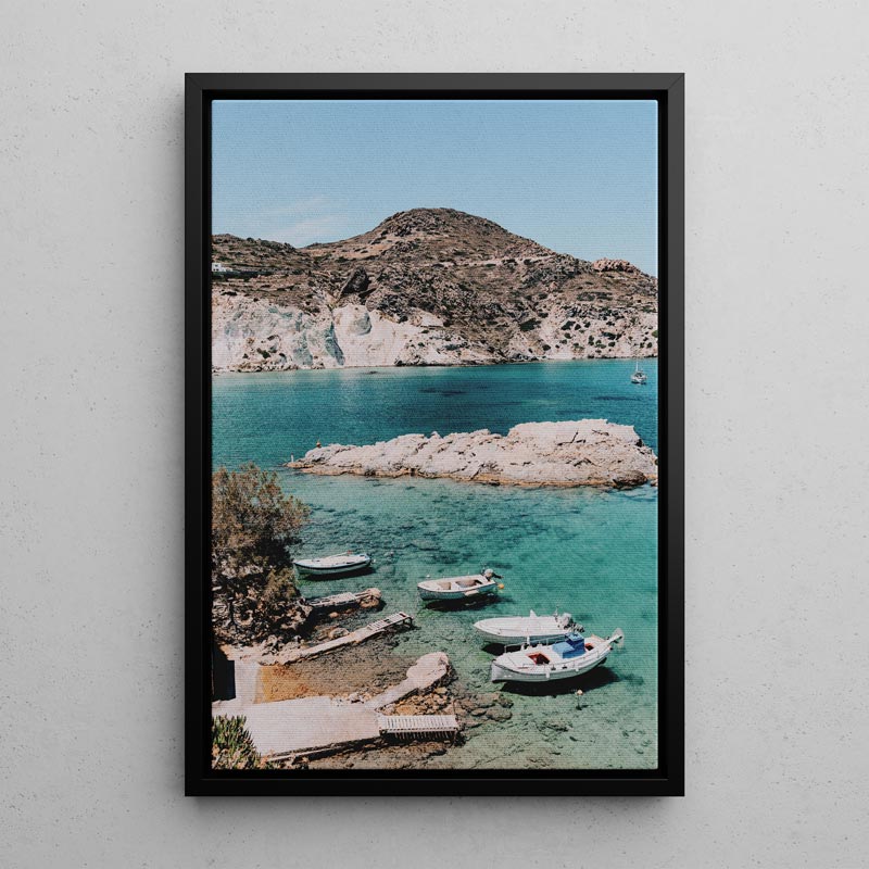 Framed photograph of a coastal scene with boats and a mountainous island.