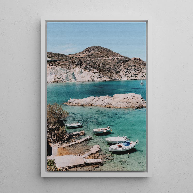 Framed photograph of a coastal scene with boats and rocky cliffs.