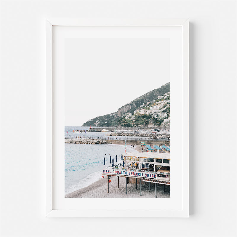 Framed photograph of a coastal scene with a mountainous background