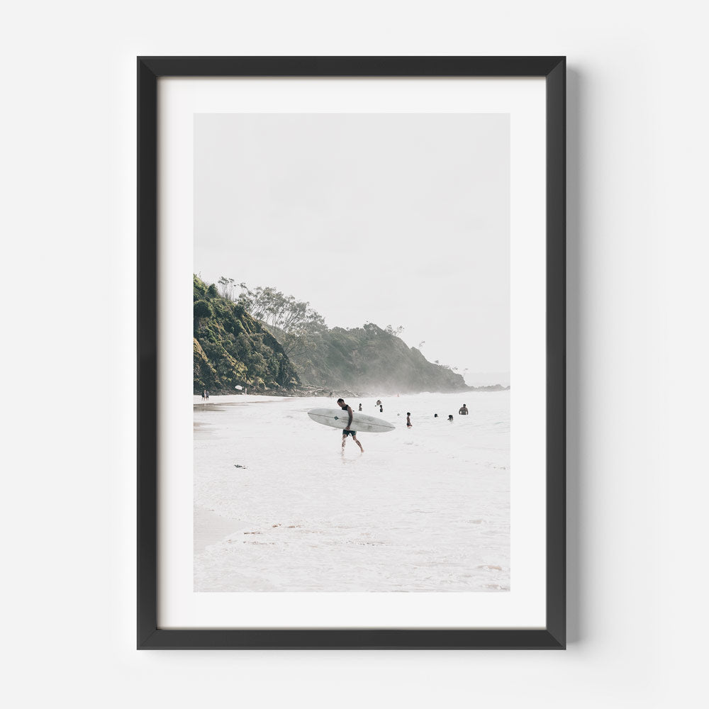 Wall artwork: Adorn your walls with the picturesque scene of North Wategos, Byron Bay, showcasing a man carrying a skateboard.