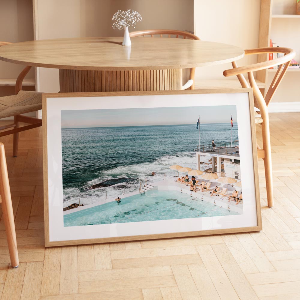 Vibrant art print of Bondi Icebergs pool with turquoise water and cheerful umbrellas, capturing the coastal spirit.